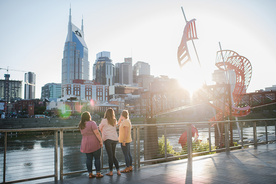 Students enjoy a walk at the park by Cumberland River and the Nashville skyline.