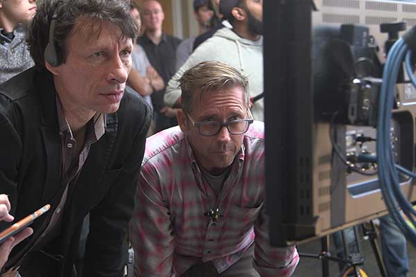 Two professors observe the work of some of the film students on a monitor