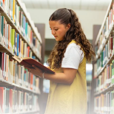 student in the library reading a book