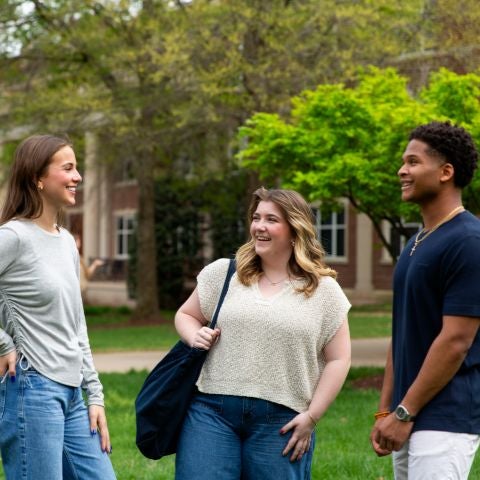 2 female students and 1 male student on campus