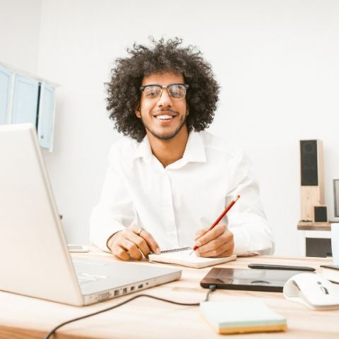 Smiling business man working laptop at home work place.