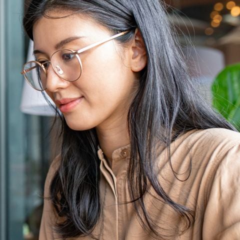 College Student Using a Laptop Computer to Study Remotely at a Cafe