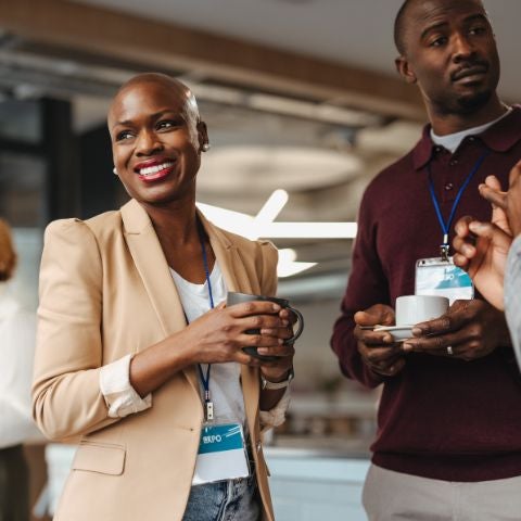 Cheerful business professionals engaging during a conference coffee break. 