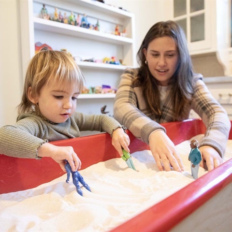 Therapist and child playing in a sand box