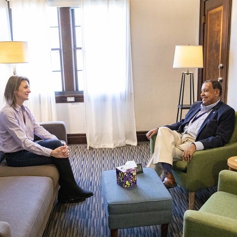 A therapist on an armchair talking to a client on a couch
