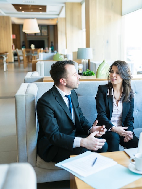 Businesspeople talking in hotel lobby.