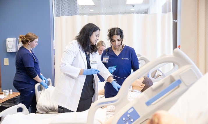 Student nurses work with a "patient".