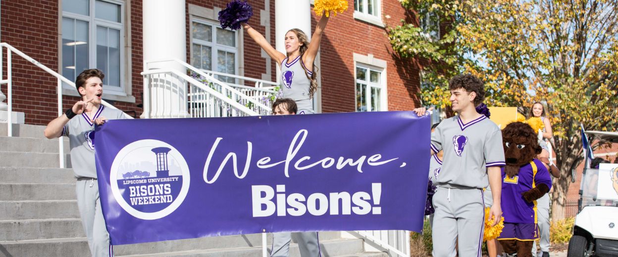 Students carry a parade banner for Bisons Weekend