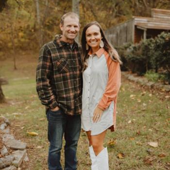 Brianna Harrell with her husband standing in a field.