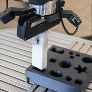 Robot arm putting a peg into the correctly shaped hole