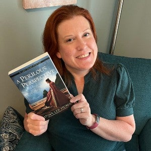 Anna Lee Huber with her book: A Perilous Perspective