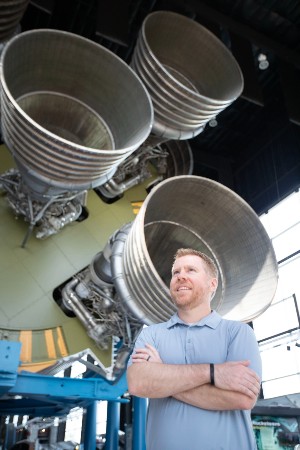 James Savage posing in front of a rocket engine