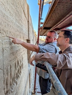 Two Lanier team members discussing the wall inscriptions
