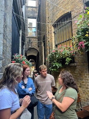 Director Kate Minchew talking with interns in London in 2025