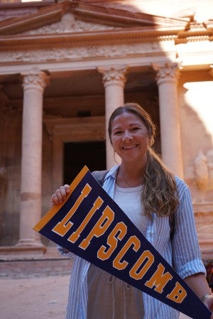 Kristen Flake showing off a Lipscomb pennant in front of Petra historic site