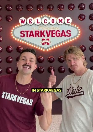 Austin & Colin pointing to a "Starkvegas" sign in Starkville, Mississippi