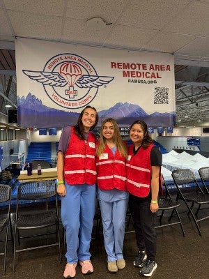 Robertson, Rocha and Jennifer Domingo Diaz, senior molecular biology major, in front of the RAM clinic banner in Harriman