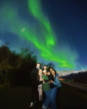students posing in front of the Northern Lights