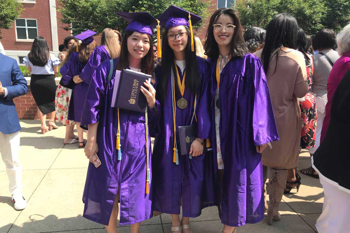 Several Global Students in purple graduation robes together. 