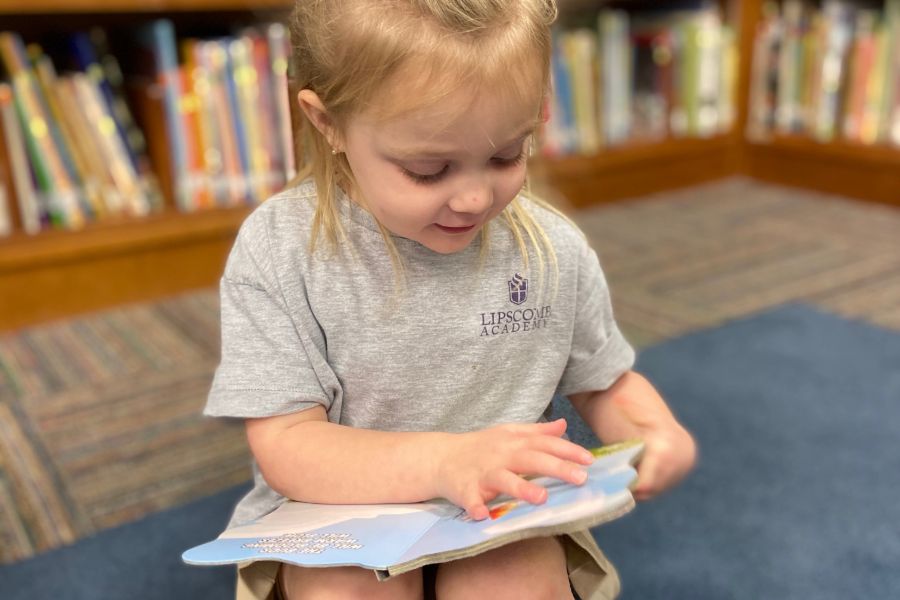 Lipscomb Academy PK3 student reading in the library