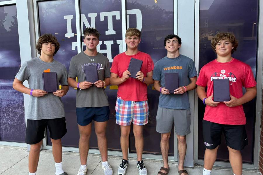 Students hold their new Bibles. 