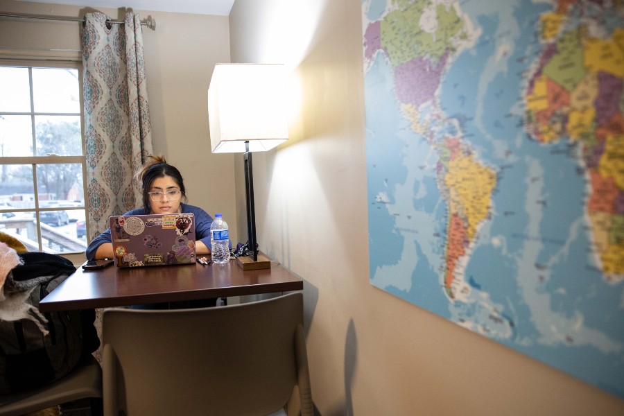 Student studying in Honors House with world map