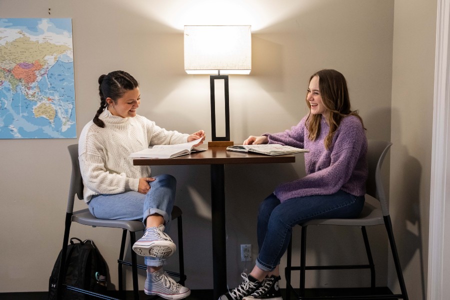 Honors Students talking at a study table inside the Honors House