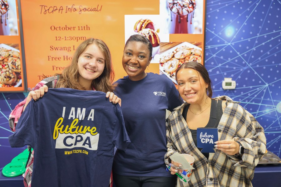 Kara Williams with two fellow accounting students with a "CPA" sweatshirt