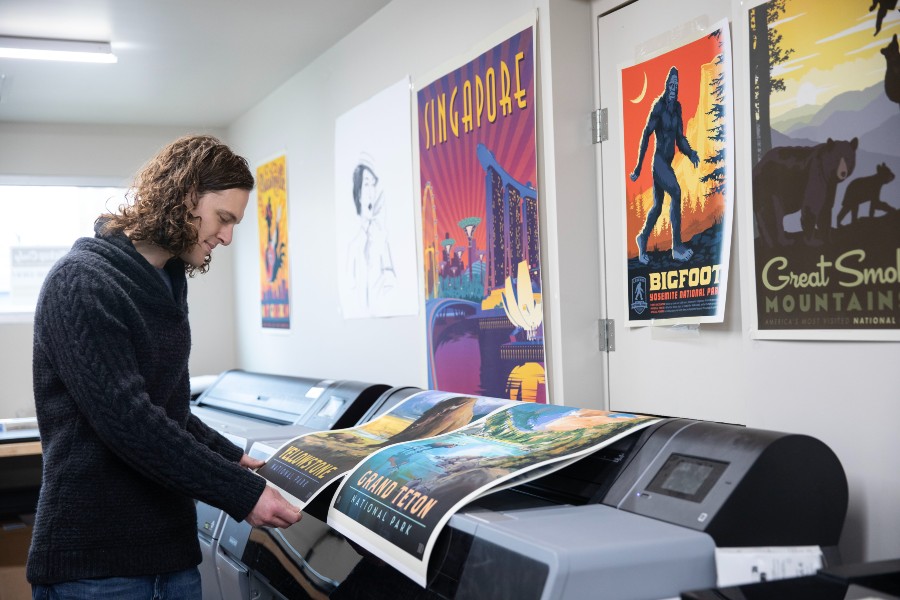 Nathan Anderson pulling posters off the printers in the studio