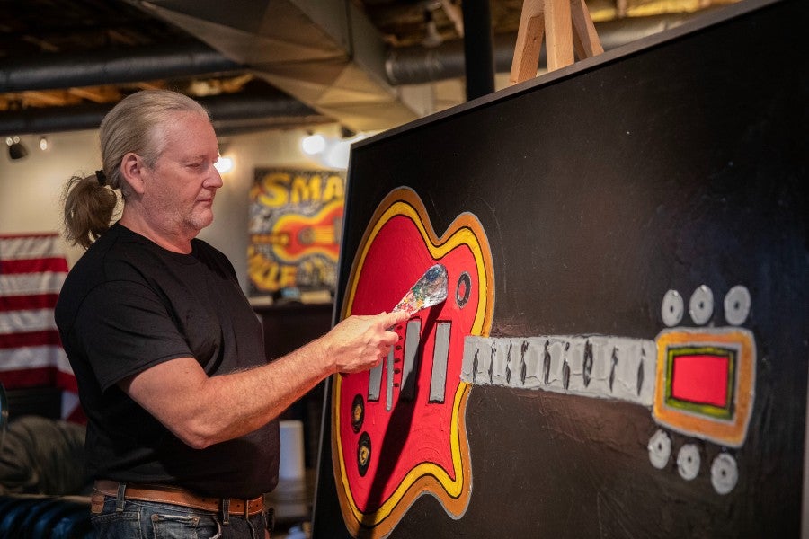 Rob Hendon painting a guitar in his studio