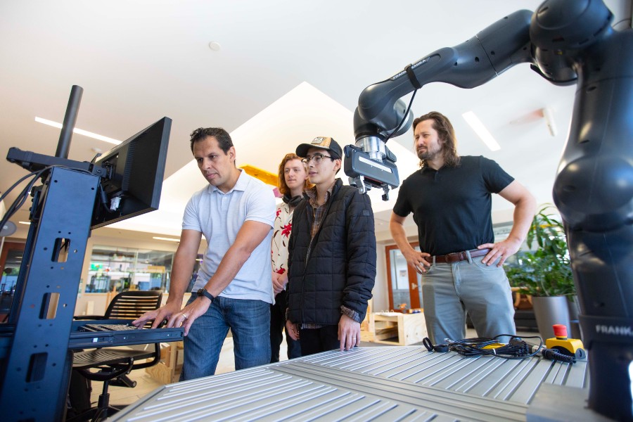 Lipscomb student and professor working with the robotic arm