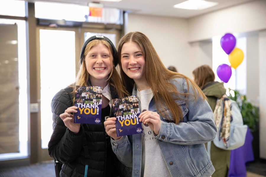 Students holding up their thank you cards they wrote for donors