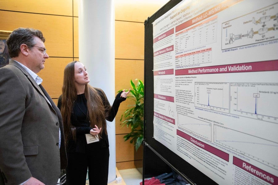 Katelyn Covington presents to he professor at the 2024 Student Scholars Symposium.