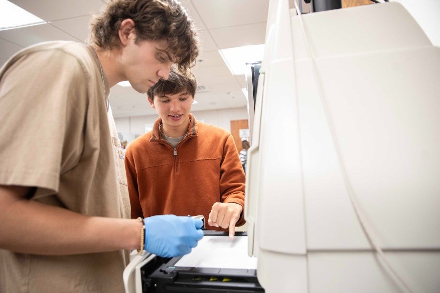 Biology student lab leader Kai Lam instructing a peer student