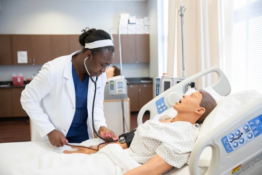A nursing student takes vitals on a patient.