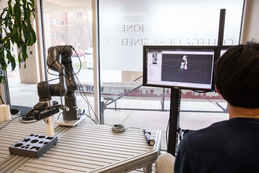 Student working with a 3-D image of the robot on a computer screen