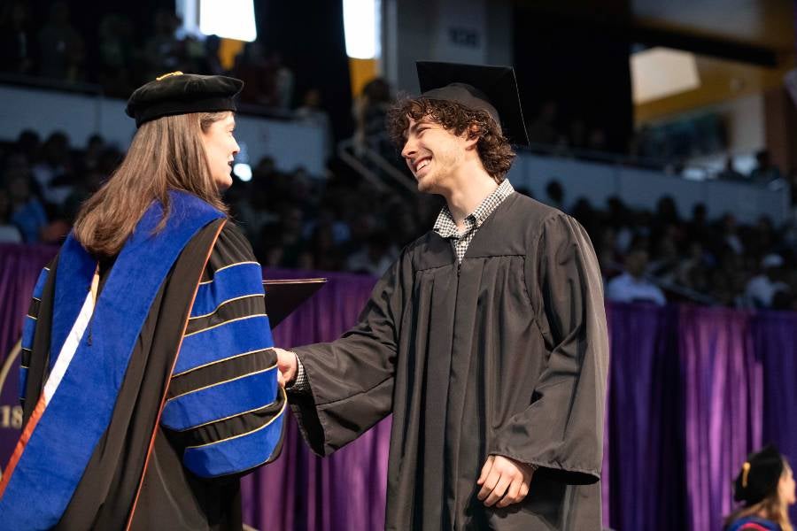 Student shaking hands with Dr. McQueen