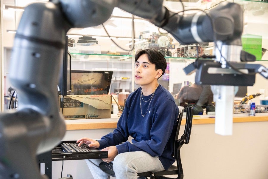 Student working with an intelligent robot arm