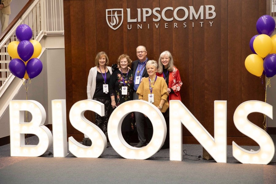 Reunion attendees posing behind Bison light-up letters with balloons