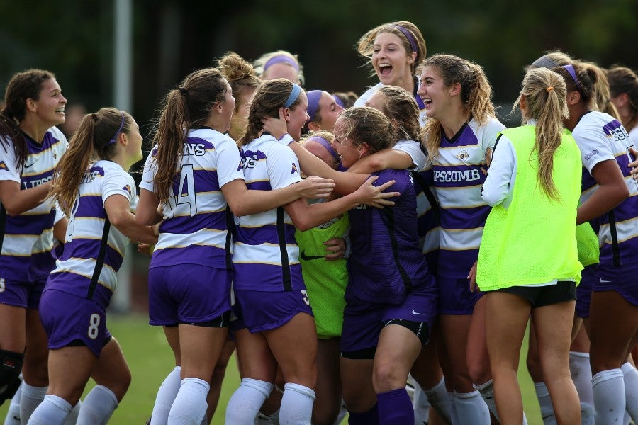 Women's soccer team celebrating after ASUN game during a past Homecoming