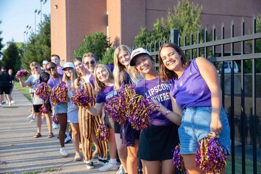 Students in purple and gold cheering for Lipscomb. 