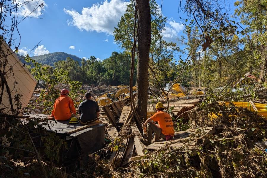 Search and rescue team members sit among the debris left in the aftermath of Helene. Photo courtesy: Andrew Harris
