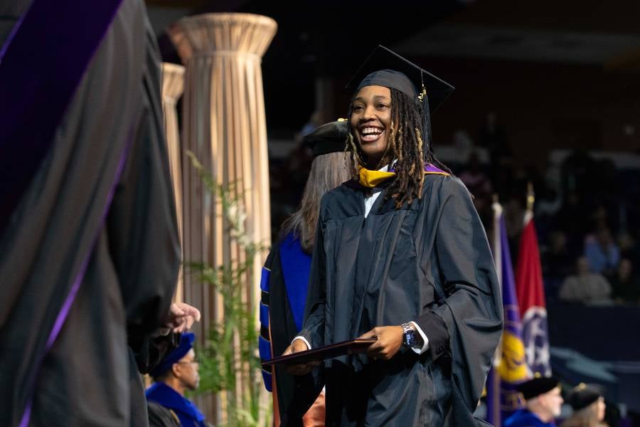 Breshonna Brumfield walks across the stage in Allen Arena to receive her diploma. 