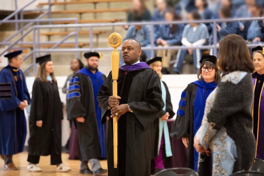 Dr. Kenneth E. Williams, principal at the Debra K. Johnson Rehabilitation Center, carries in the mace. 