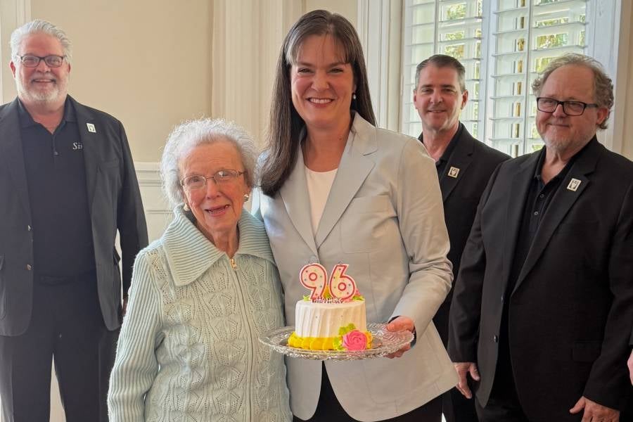 Lipscomb President Candice McQueen holding a birthday cake to celebrate Chumley's 96th birthday. 