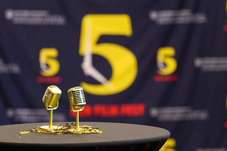 two golden microphone trophies for the 5mff on a table