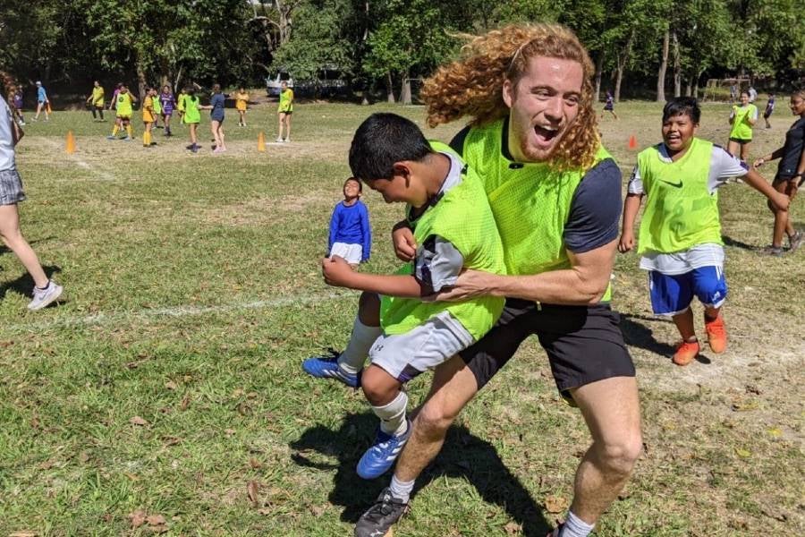 Bryan playing soccer with a young boy. 