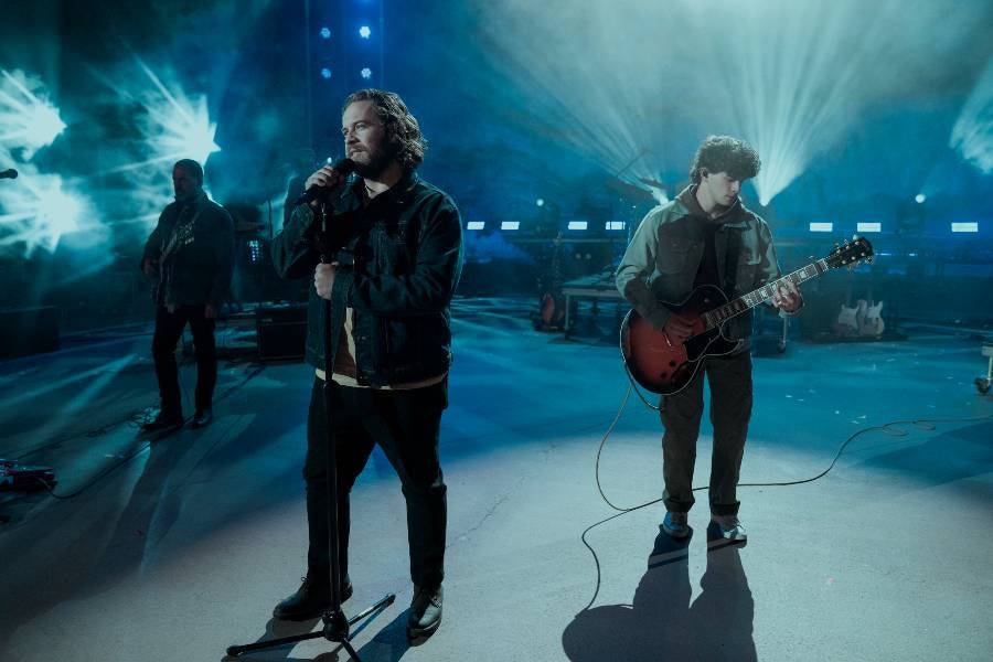 Two male performers on stage singing. 