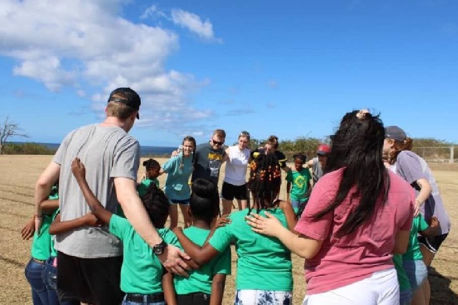 Groups of people standing in a circle outside in Nevis