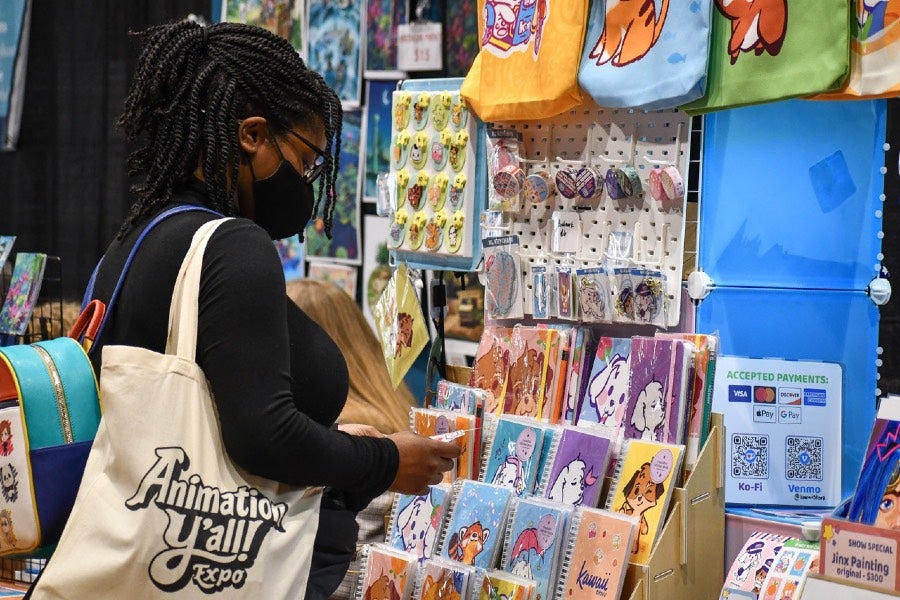 Student looks at animation exhibition booths. 